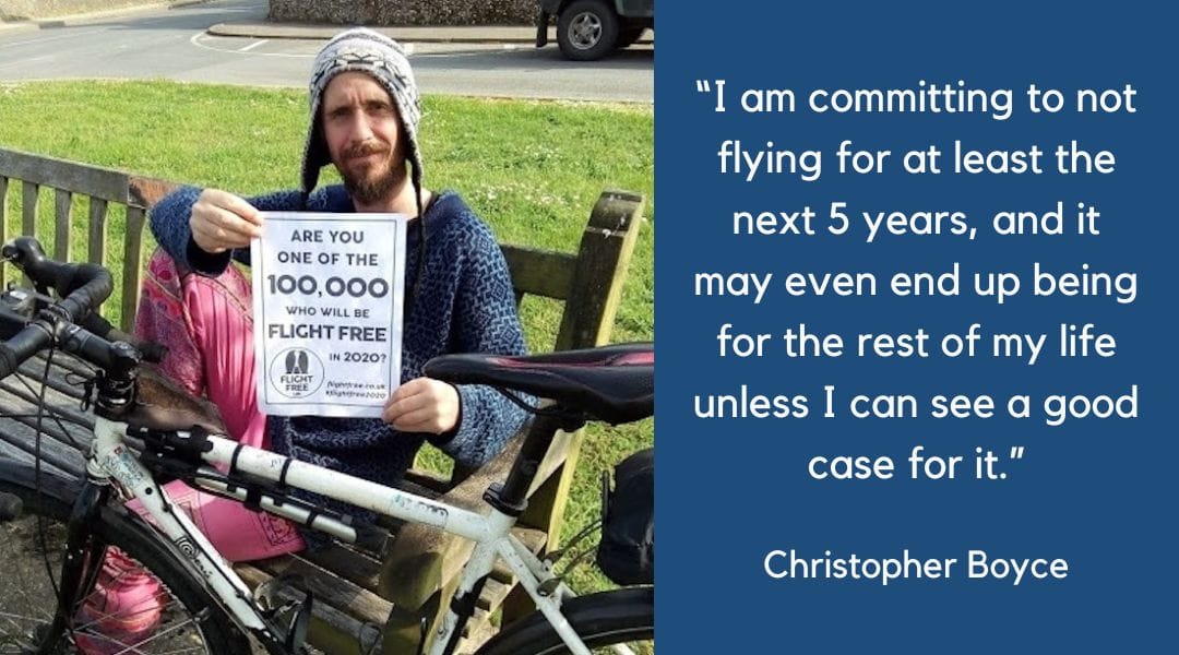 Picture shows man on bicycle parked at the side of a mountain road. He has his back to the camera and is looking over the edge. In the distance are mountain tops and rolling clouds.