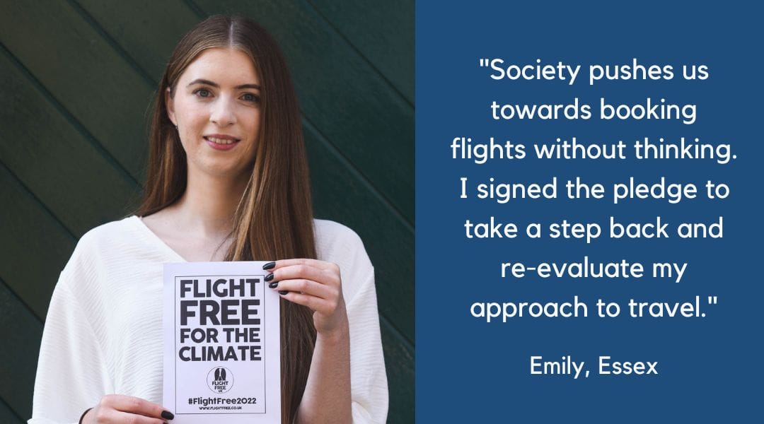 Image shows Emily, a young white woman, wearing a white top and holding a sign that says Flight Free for the Climate.