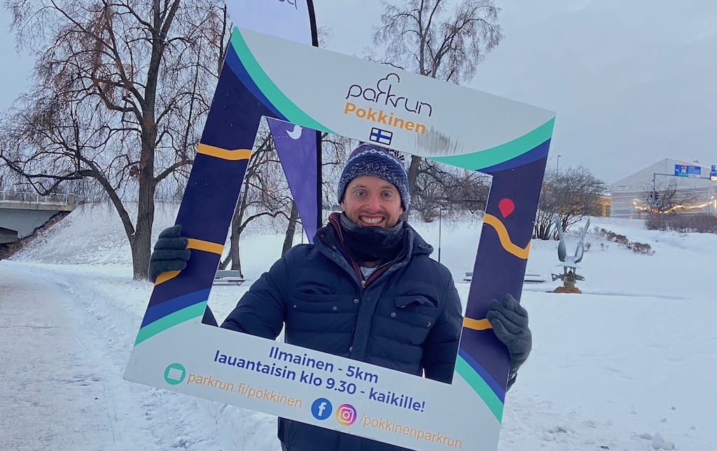 Chris Russell holds the Parkrun sign in a very snowy Oulu
